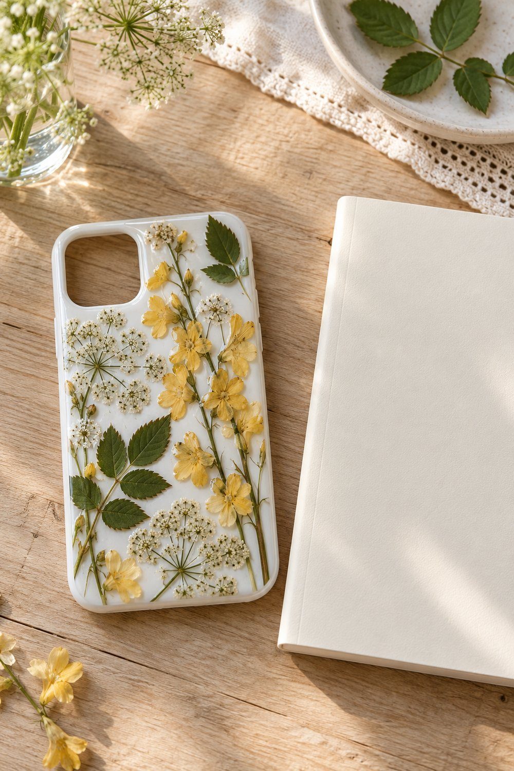 White phone case decorated with pressed yellow larkspur and Queen Anne’s lace
