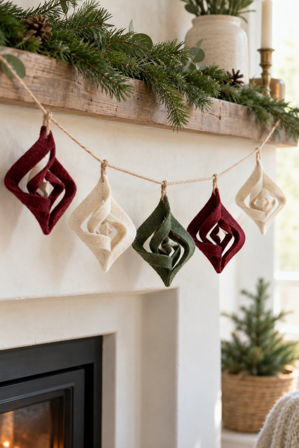 Burgundy cream and green sculptural felt shapes made from curled cut squares hang along a